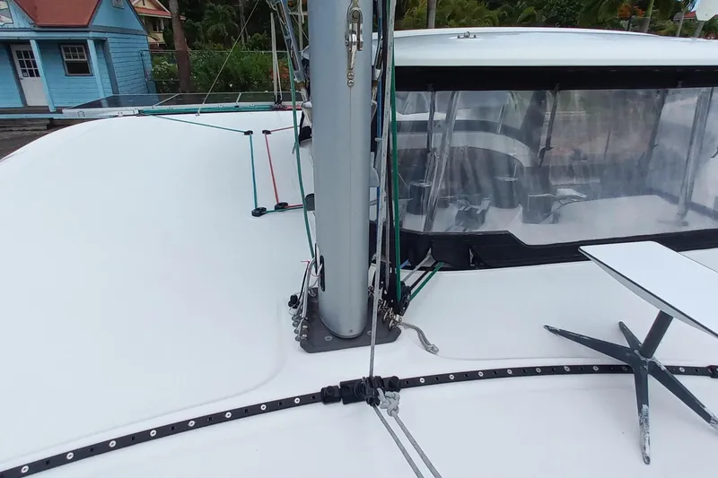 Always Sunday Yacht Photos Pics 2020 Lagoon 42 catamaran deck with mast and rigging, docked near colorful buildings.