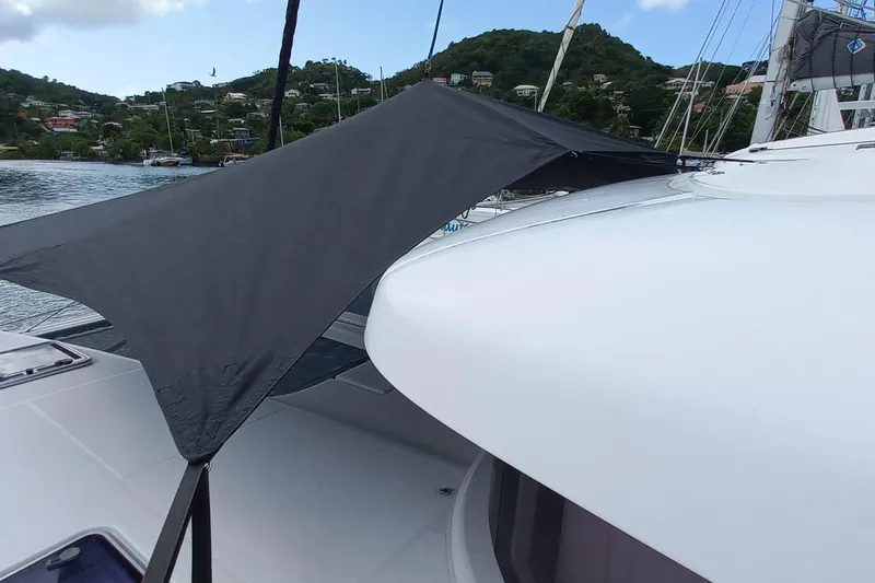Always Sunday Yacht Photos Pics Lagoon 42 catamaran (2020) with sunshade, docked near lush green hills.
