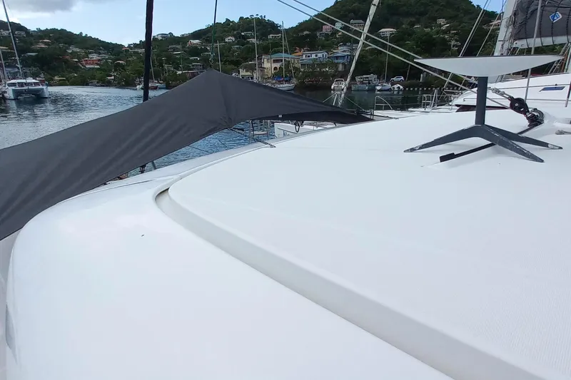 Always Sunday Yacht Photos Pics 2020 Lagoon 42 catamaran docked in a scenic harbor with lush hills.
