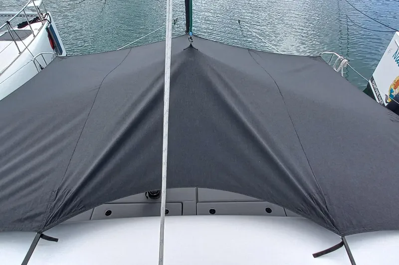 Always Sunday Yacht Photos Pics 2020 Lagoon 42 catamaran with a dark canopy, docked on calm water.