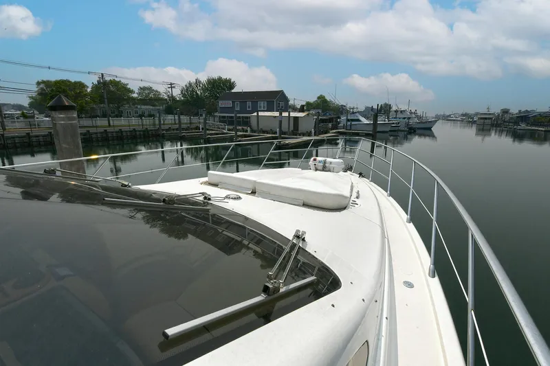  Yacht Photos Pics 2003 Azimut 62 yacht docked in a serene marina setting.