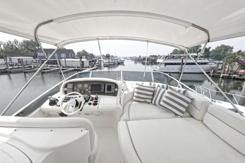  Yacht Photos Pics Luxurious 2003 Azimut 62 yacht interior with helm and plush seating in marina.