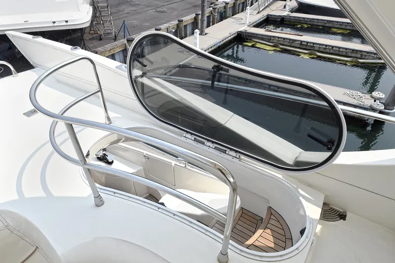  Yacht Photos Pics 2003 Azimut 62 yacht deck with sleek railing and hatch, docked by the water.