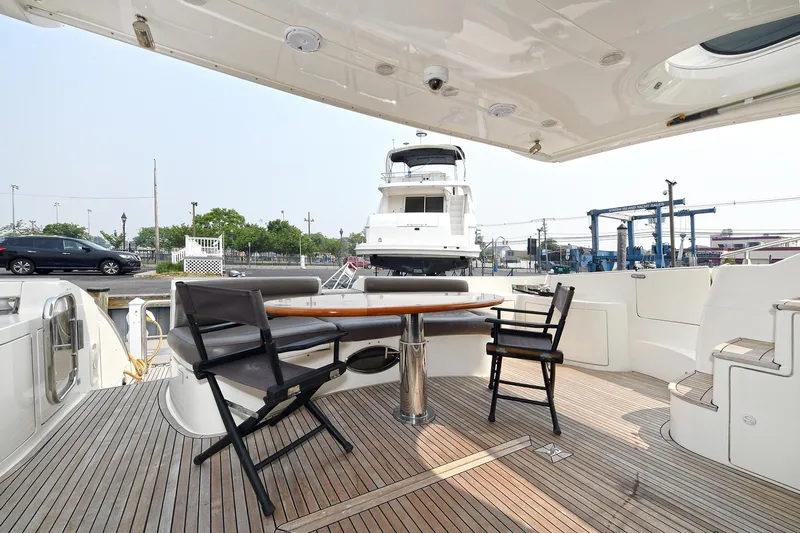  Yacht Photos Pics Outdoor seating area on a 2003 Azimut 62 yacht with wooden deck and chairs.