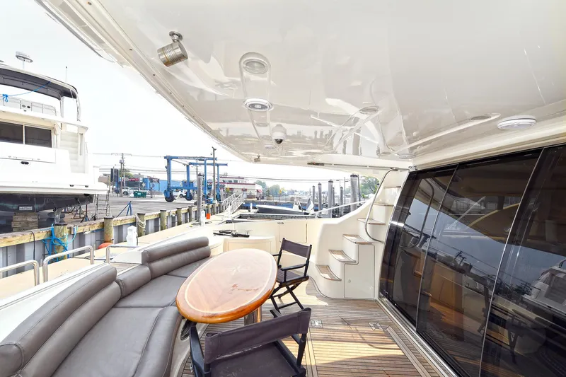  Yacht Photos Pics Luxurious 2003 Azimut 62 yacht deck with seating and table, docked at marina.