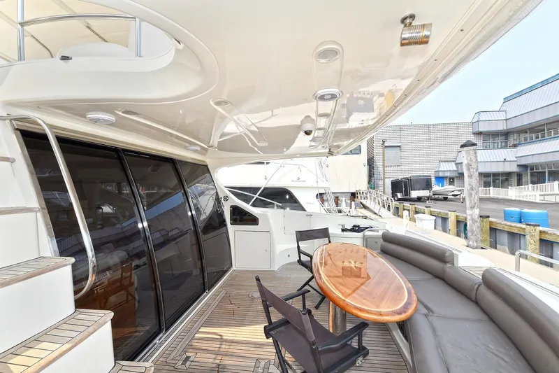  Yacht Photos Pics Luxurious 2003 Azimut 62 yacht deck with seating and table, docked at marina.