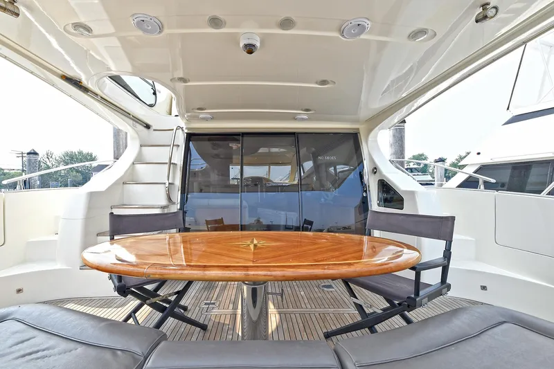  Yacht Photos Pics Luxurious 2003 Azimut 62 yacht interior with elegant wooden table and seating area.