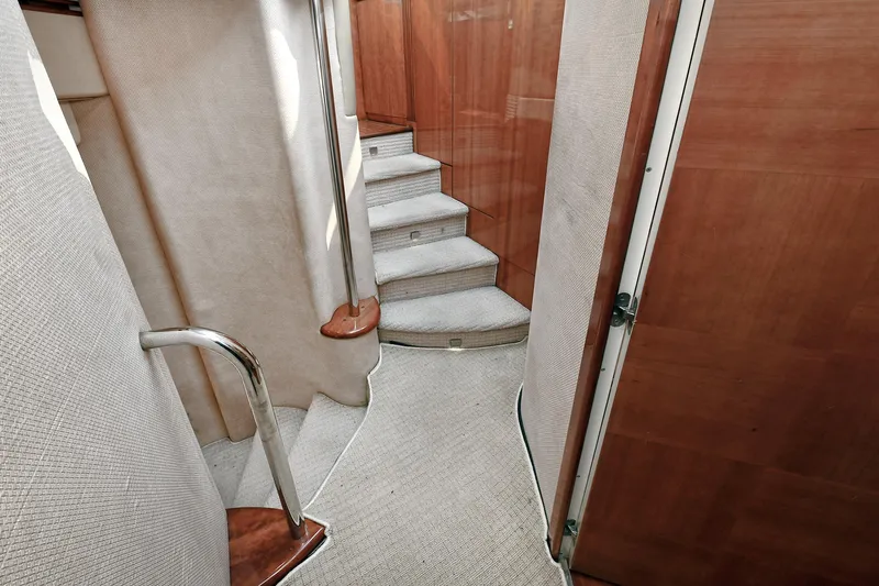  Yacht Photos Pics Interior staircase of 2003 Azimut 62 yacht with carpeted steps and wooden accents.