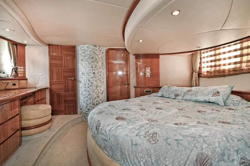  Yacht Photos Pics Luxurious bedroom interior of a 2003 Azimut 62 yacht with elegant wood finishes.