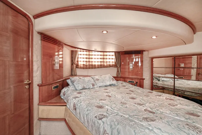  Yacht Photos Pics Luxurious bedroom interior of a 2003 Azimut 62 yacht with elegant wood finishes.