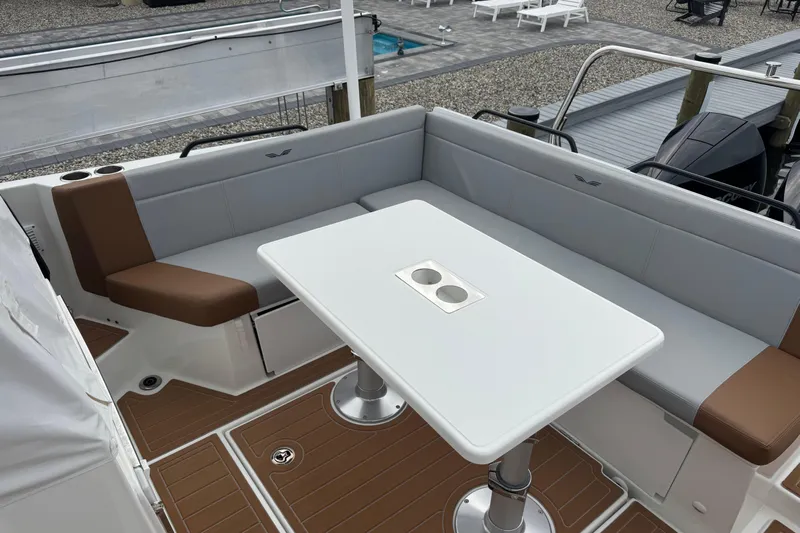  Yacht Photos Pics 2024 Beneteau Flyer 9 SUNdeck boat interior with seating and table, docked outdoors.