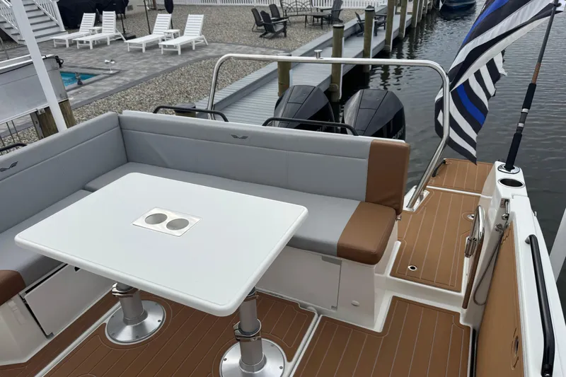  Yacht Photos Pics 2024 Beneteau Flyer 9 SUNdeck with seating area and table, docked by the water.