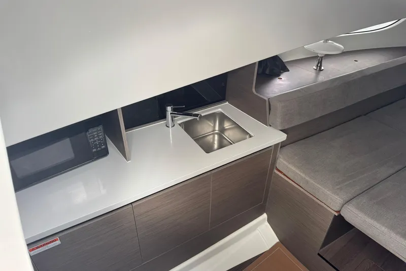  Yacht Photos Pics 2024 Beneteau Flyer 9 SUNdeck interior with kitchenette and seating area.