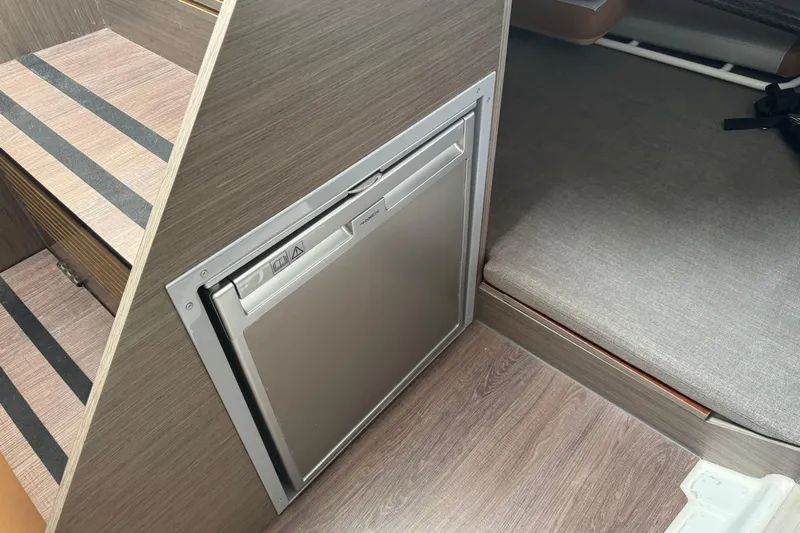  Yacht Photos Pics 2024 Beneteau Flyer 9 SUNdeck interior with compact fridge and seating area.