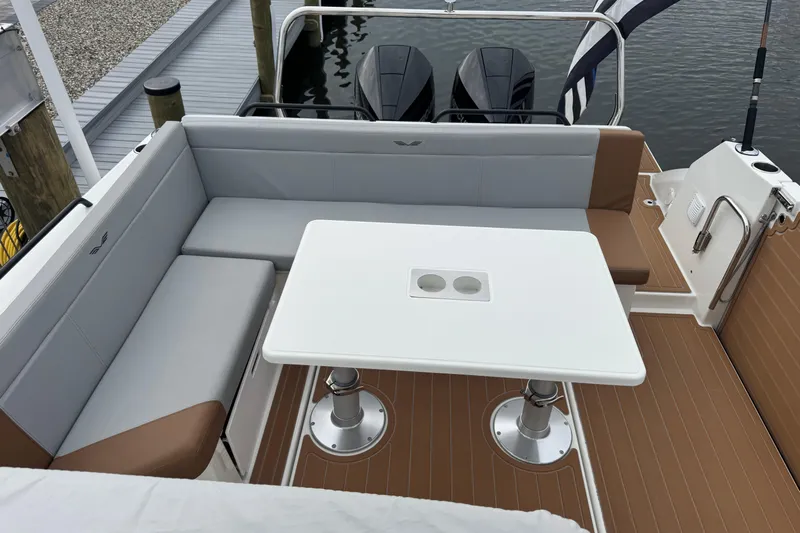  Yacht Photos Pics 2024 Beneteau Flyer 9 SUNdeck boat interior with seating and table, docked by the water.