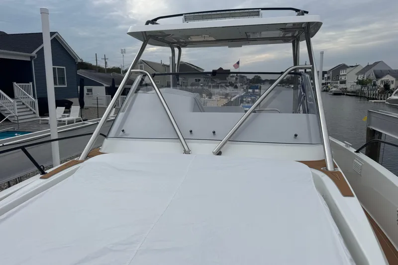  Yacht Photos Pics 2024 Beneteau Flyer 9 SUNdeck at a marina, showcasing sleek design and spacious deck.