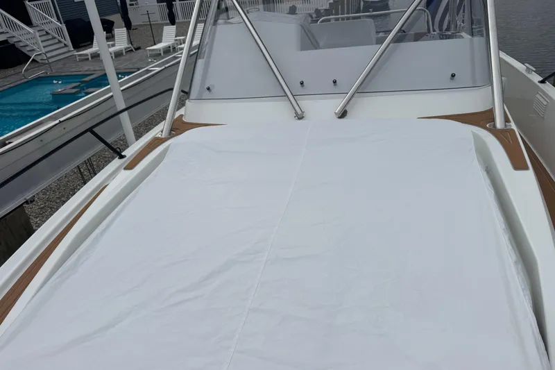  Yacht Photos Pics 2024 Beneteau Flyer 9 SUNdeck with covered deck, docked near a poolside area.