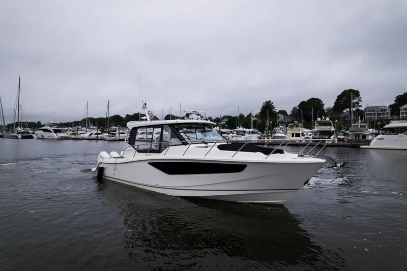  Yacht Photos Pics 2024 Boston Whaler 405 Conquest boat docked in a marina, surrounded by other vessels.