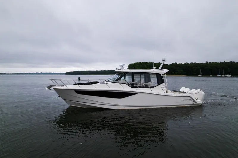  Yacht Photos Pics 2024 Boston Whaler 405 Conquest boat on calm water, overcast sky.