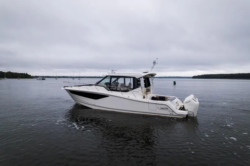  Yacht Photos Pics 2024 Boston Whaler 405 Conquest boat on calm water under cloudy skies.