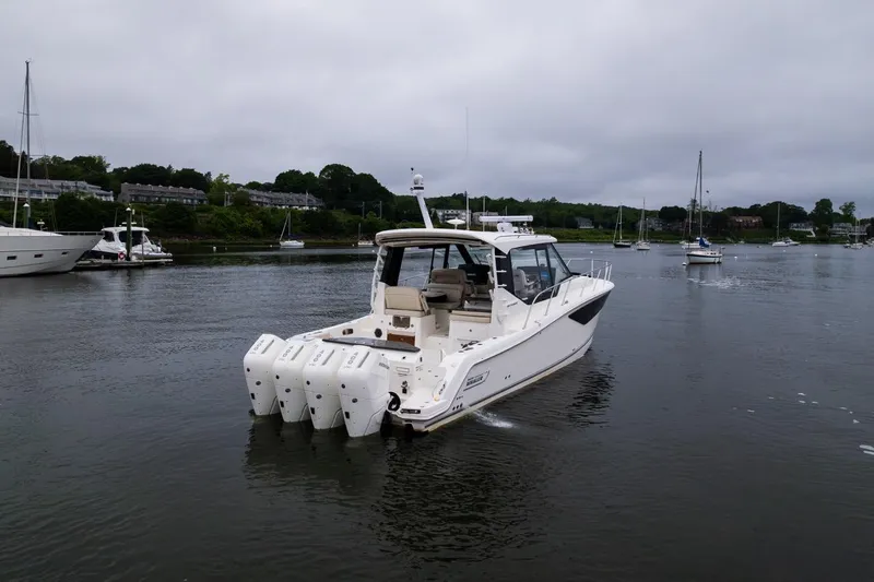  Yacht Photos Pics 2024 Boston Whaler 405 Conquest boat on calm water, surrounded by other vessels.