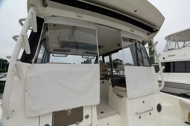  Yacht Photos Pics 2024 Boston Whaler 405 Conquest boat interior with covered windows at a marina.
