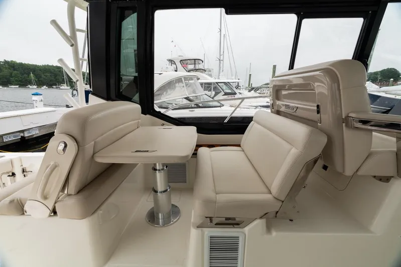  Yacht Photos Pics 2024 Boston Whaler 405 Conquest interior seating area with table, docked at marina.