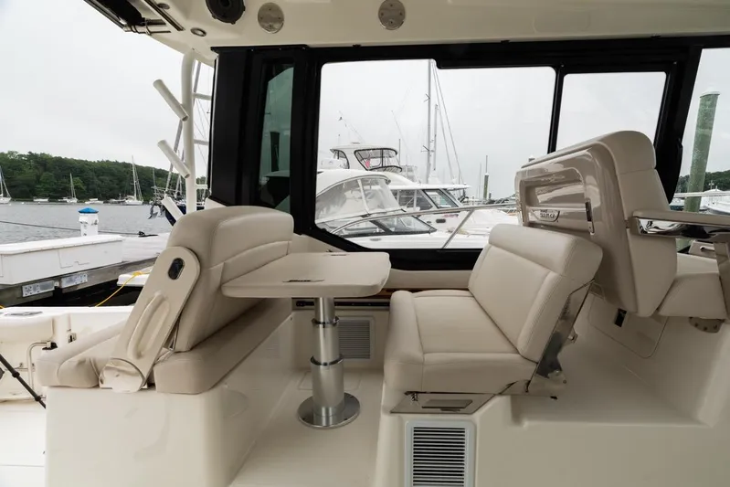  Yacht Photos Pics 2024 Boston Whaler 405 Conquest interior with plush seating and table, docked at marina.