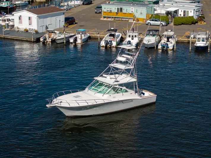 Ryfly Yacht Photos Pics 2004 Cabo 40 Express boat docked in a marina, surrounded by other vessels.