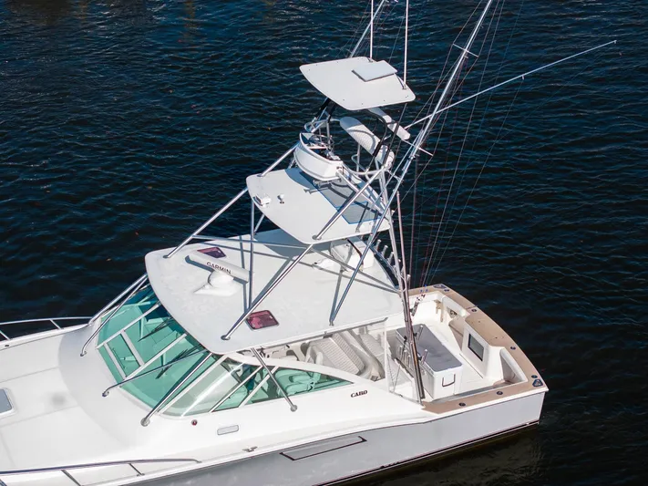 Ryfly Yacht Photos Pics 2004 Cabo 40 Express boat with tower on calm water.