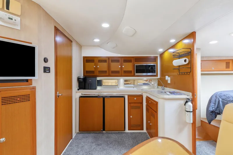 Ryfly Yacht Photos Pics Interior of 2004 Cabo 40 Express yacht with kitchen and seating area.