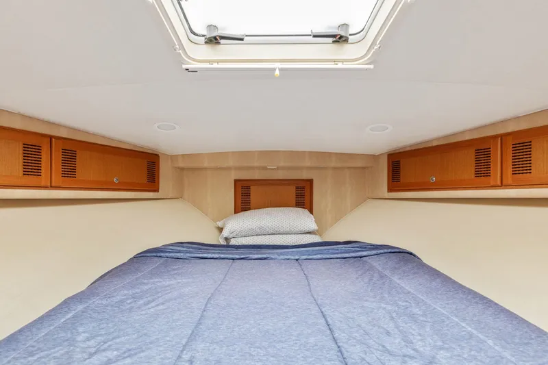 Ryfly Yacht Photos Pics 2004 Cabo 40 Express cabin interior with bed and overhead storage.