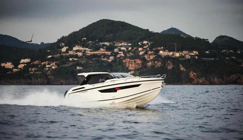  Yacht Photos Pics 2025 Skamander Sorrento boat cruising on water with scenic mountain backdrop.