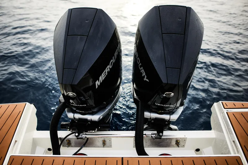  Yacht Photos Pics Twin Mercury outboard engines on a 2025 Skamander Sorrento boat, floating on calm water.