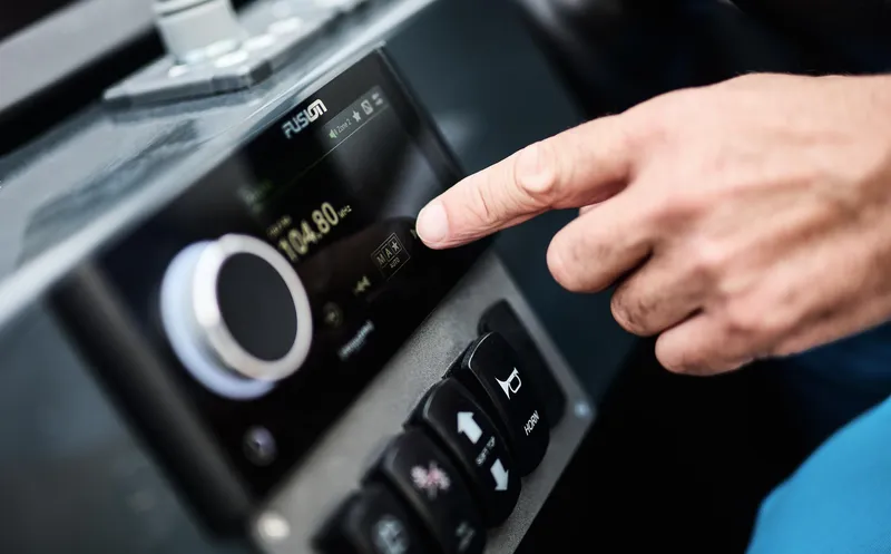  Yacht Photos Pics Person adjusting Skamander Sorrento 2025 dashboard controls, focusing on digital display.
