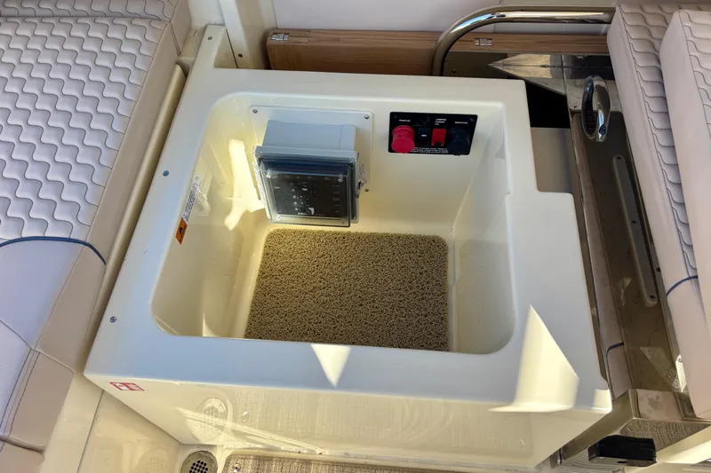  Yacht Photos Pics 2026 Chris-Craft Launch 31 GT boat storage compartment with control panel and cushioned seating.