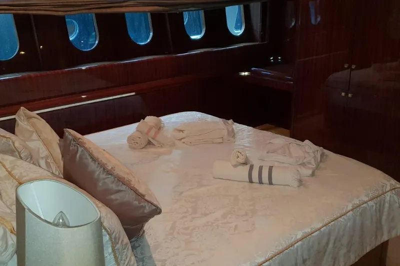  Yacht Photos Pics Luxurious bedroom interior on a 2008 Leopard 105 yacht with elegant bedding and porthole windows.