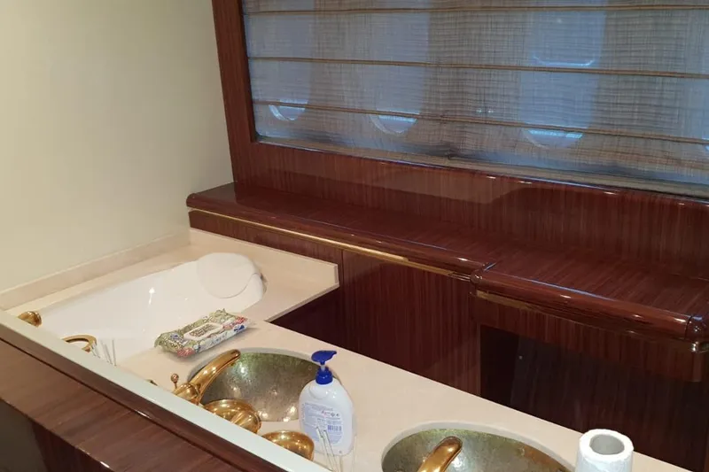  Yacht Photos Pics Luxurious yacht bathroom with gold fixtures, wooden accents, and a porthole window. Leopard 105, 2008.