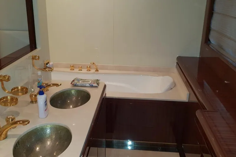  Yacht Photos Pics Luxurious bathroom with dual sinks, gold fixtures, and a bathtub on a 2008 Leopard 105 yacht.