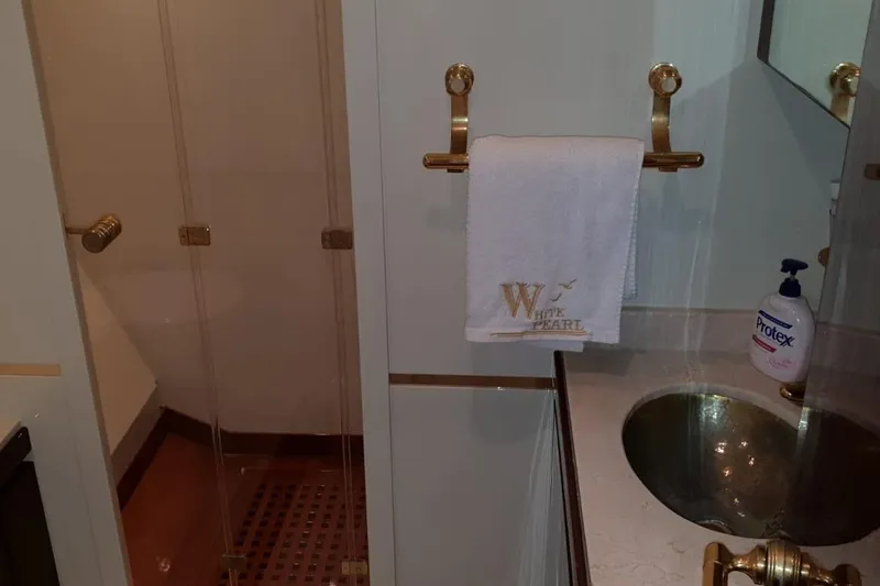  Yacht Photos Pics Luxurious yacht bathroom with gold fixtures, glass shower, and branded towel. Leopard 105, 2008 model.