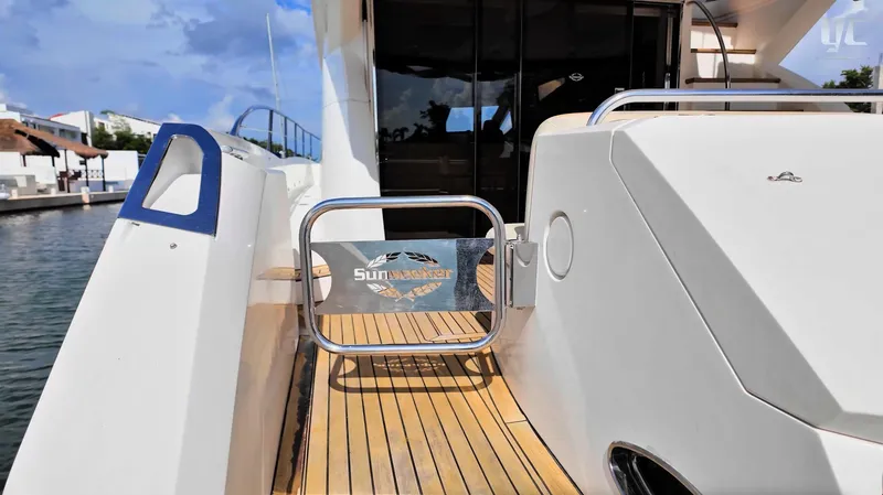 Phantom Yacht Photos Pics 2011 Sunseeker Manhattan 63 yacht deck with branded gate, docked by the water.