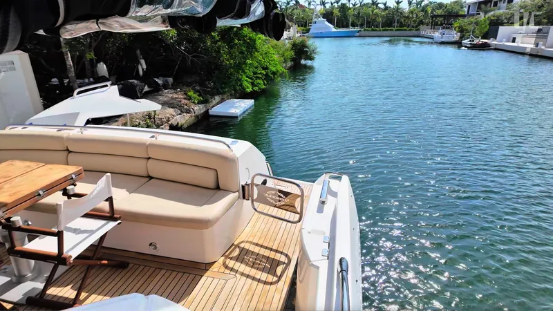 Phantom Yacht Photos Pics Luxurious Sunseeker Manhattan 63 yacht deck with seating, overlooking serene waterway.