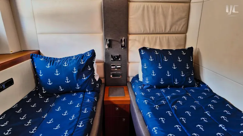 Phantom Yacht Photos Pics Twin beds with nautical-themed bedding in a 2011 Sunseeker Manhattan 63 yacht cabin.