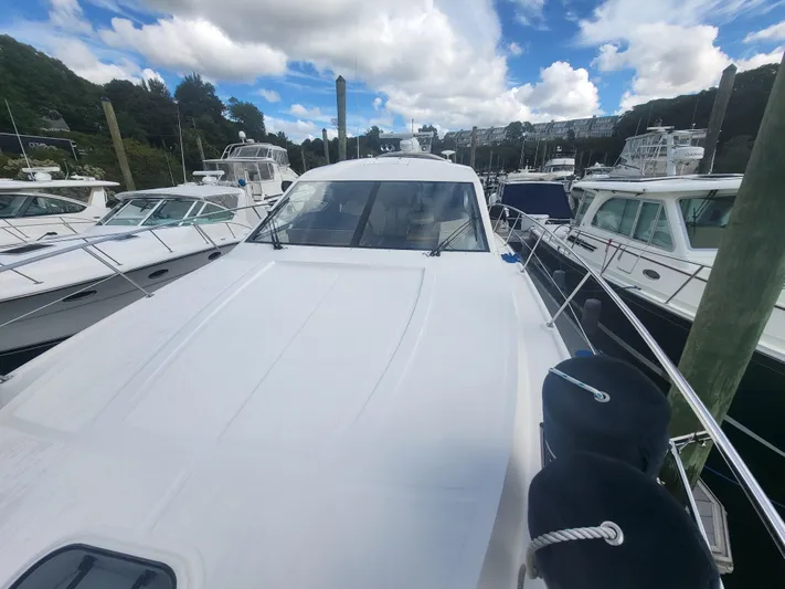 Tam- E- Lee Yacht Photos Pics 2013 Sea Ray 510 Sundancer yacht docked among other boats under a partly cloudy sky.