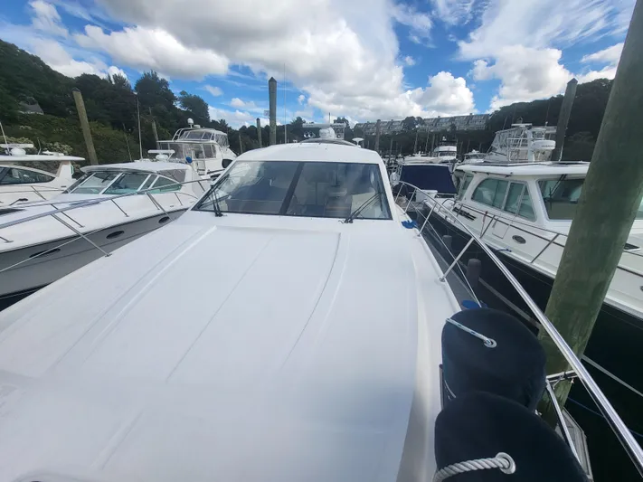 Tam- E- Lee Yacht Photos Pics 2013 Sea Ray 510 Sundancer yacht docked among other boats under a partly cloudy sky.
