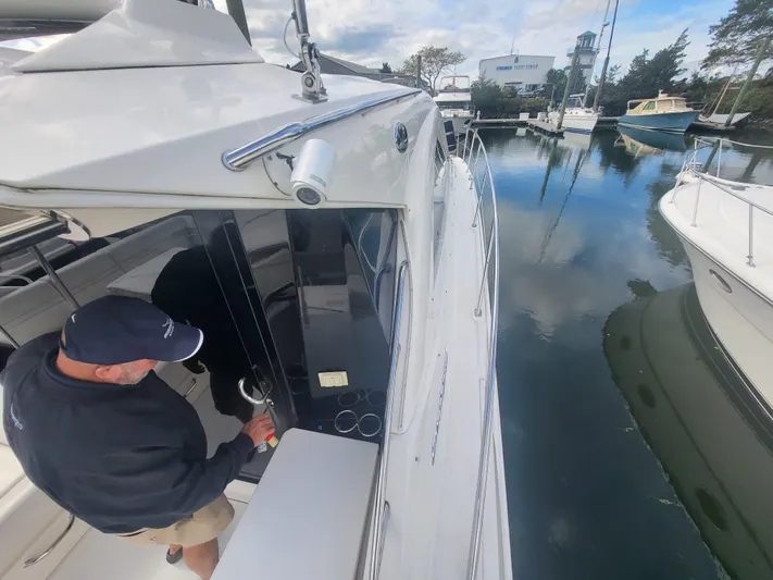 Tam- E- Lee Yacht Photos Pics 2013 Sea Ray 510 Sundancer docked, man entering cabin, calm marina waters.