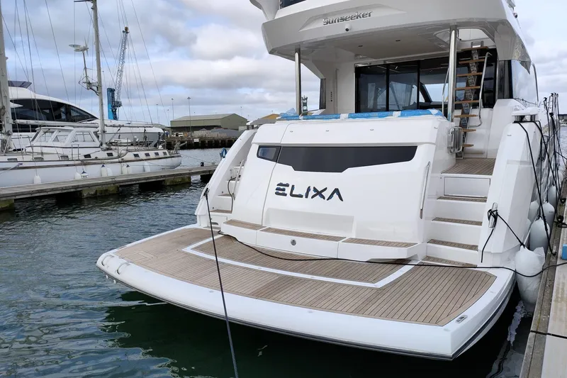 Elixa Yacht Photos Pics 2022 Sunseeker Manhattan 68 yacht docked, showcasing elegant design and spacious deck.