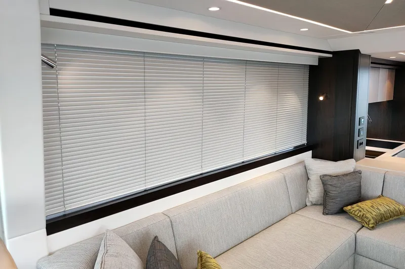 Elixa Yacht Photos Pics Luxurious interior of 2022 Sunseeker Manhattan 68 yacht with modern blinds and plush seating.