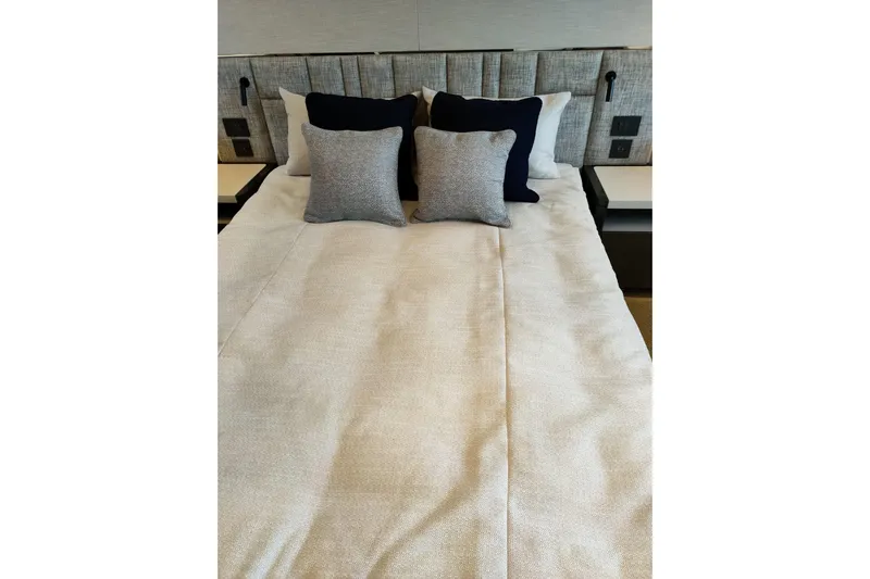 Elixa Yacht Photos Pics Luxurious bedroom interior of 2022 Sunseeker Manhattan 68 yacht with elegant bedding and cushions.