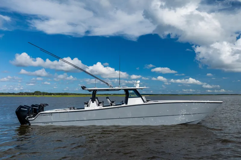  Yacht Photos Pics 2023 Freeman 47 boat on calm water under a blue sky with clouds.